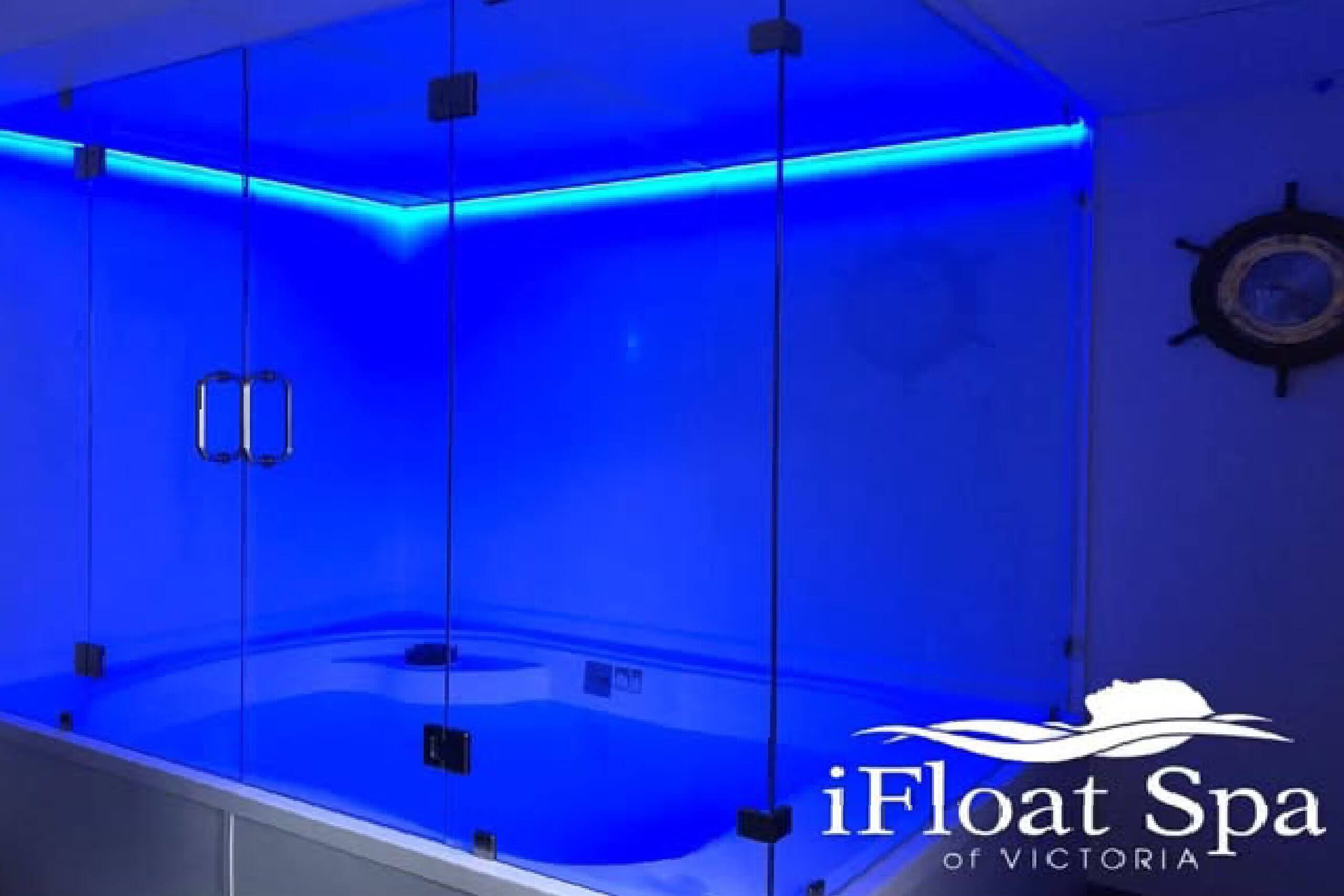 Modern floatation tank illuminated with blue lighting.